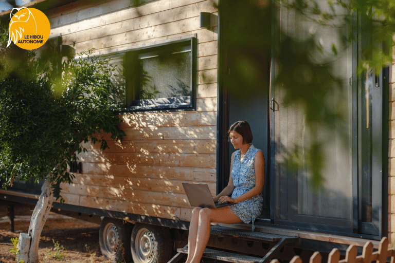femme assise devant sa tiny house autonome